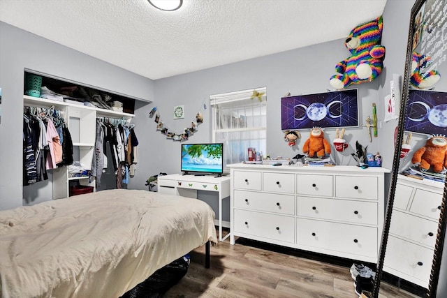 6816 Thomas Cir, Tampa, FL 33619 - bedroom featuring wood finished floors, a textured ceiling, and a closet