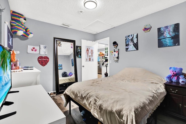6816 Thomas Cir, Tampa, FL 33619 - bedroom with attic access, a textured ceiling, and wood finished floors