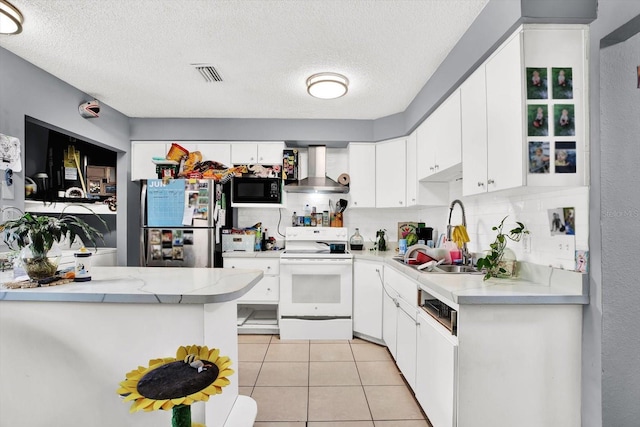 6816 Thomas Cir, Tampa, FL 33619 - kitchen featuring electric range, wall chimney exhaust hood, freestanding refrigerator, black microwave, and a textured ceiling