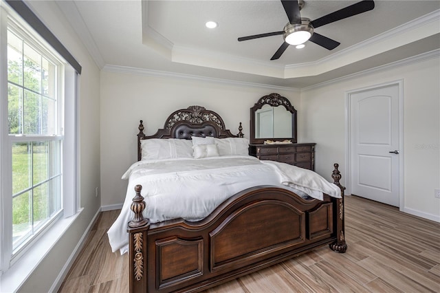 5331 SW 121st Ter, Ocala, FL 34481 - bedroom with multiple windows, a tray ceiling, crown molding, and light wood-style floors