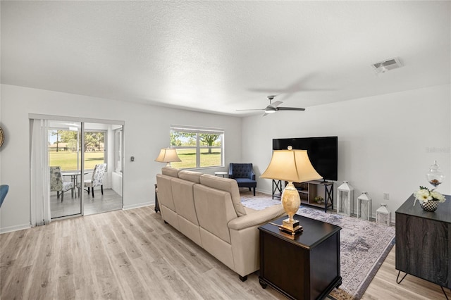 9735 SW 96th St, Ocala, FL 34481 - living area featuring a ceiling fan, light wood finished floors, and a textured ceiling