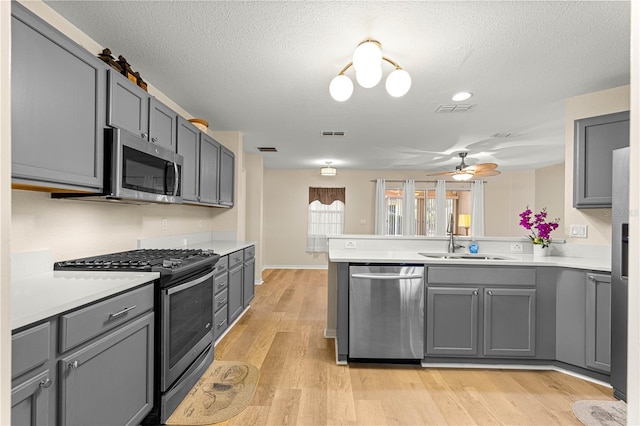 8034 SW 81st Loop, Ocala, FL 34476 - kitchen with stainless steel appliances, a peninsula, gray cabinets, a ceiling fan, and a textured ceiling