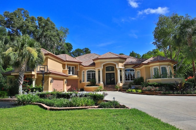 695 SE 47th Loop, Ocala, FL 34480 - mediterranean / spanish home with stucco siding, a garage, driveway, a front yard, and french doors