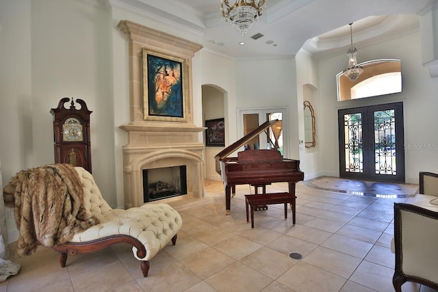 695 SE 47th Loop, Ocala, FL 34480 - foyer with a chandelier, a towering ceiling, french doors, crown molding, and a large fireplace