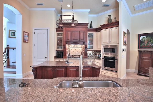 695 SE 47th Loop, Ocala, FL 34480 - kitchen featuring stainless steel appliances, arched walkways, decorative backsplash, dark stone counters, and ornamental molding