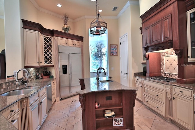 695 SE 47th Loop, Ocala, FL 34480 - kitchen featuring stainless steel appliances, decorative backsplash, a kitchen island with sink, dark stone counters, and crown molding