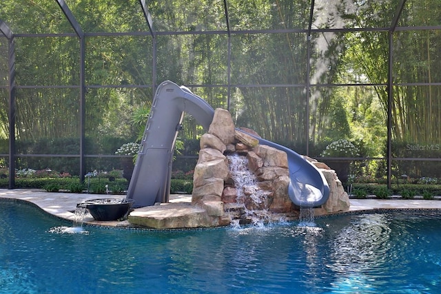 695 SE 47th Loop, Ocala, FL 34480 - swimming pool featuring a water slide, a lanai, and a view of trees