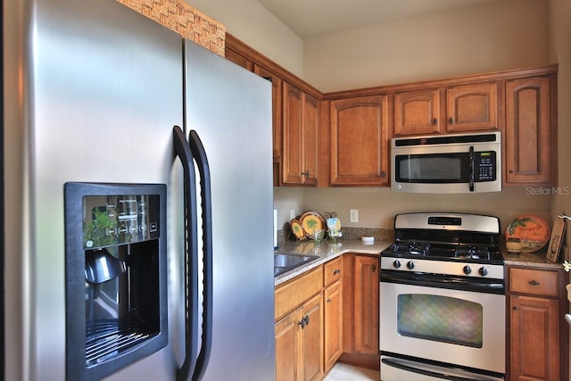 695 SE 47th Loop, Ocala, FL 34480 - kitchen featuring appliances with stainless steel finishes, light stone countertops, and brown cabinets