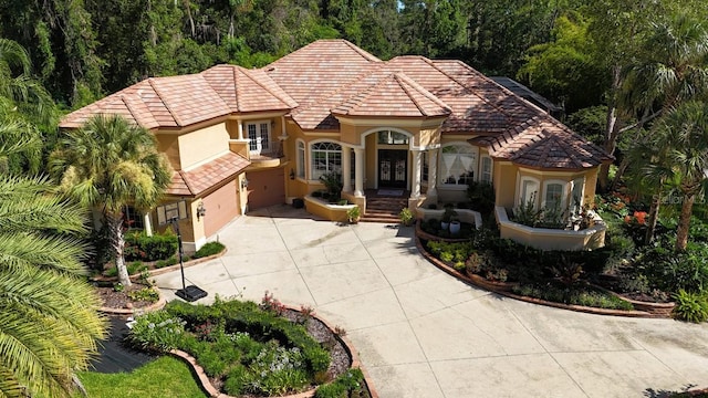 695 SE 47th Loop, Ocala, FL 34480 - mediterranean / spanish house with concrete driveway, a tiled roof, stucco siding, a garage, and french doors
