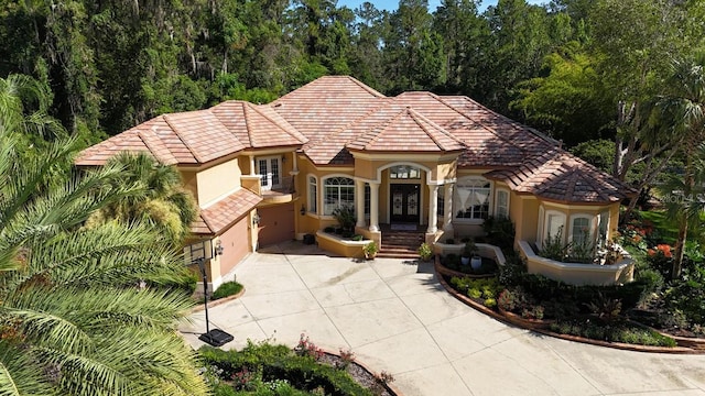 695 SE 47th Loop, Ocala, FL 34480 - mediterranean / spanish-style home with stucco siding, driveway, a tile roof, and french doors