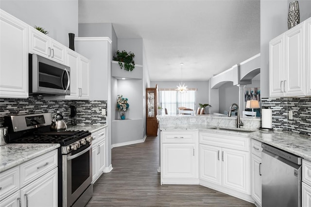 1584 Silhouette Dr, Clermont, FL 34711 - kitchen featuring stainless steel appliances, arched walkways, decorative columns, tasteful backsplash, and white cabinets