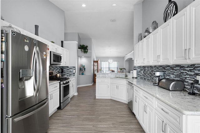 1584 Silhouette Dr, Clermont, FL 34711 - kitchen featuring appliances with stainless steel finishes, a peninsula, white cabinets, backsplash, and recessed lighting