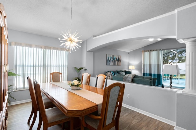 1584 Silhouette Dr, Clermont, FL 34711 - dining area featuring a textured ceiling, wood finished floors, a chandelier, arched walkways, and decorative columns