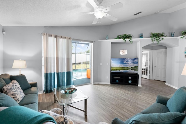 1584 Silhouette Dr, Clermont, FL 34711 - living area featuring vaulted ceiling, wood finished floors, a ceiling fan, and a textured ceiling