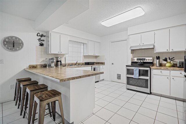 12178 Palmetto Way, Dunnellon, FL 34432 - kitchen with double oven range, dishwashing machine, under cabinet range hood, backsplash, and a textured ceiling