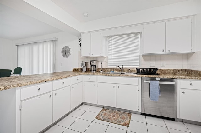 12178 Palmetto Way, Dunnellon, FL 34432 - kitchen with stainless steel dishwasher, white cabinetry, decorative backsplash, light tile patterned floors, and a peninsula