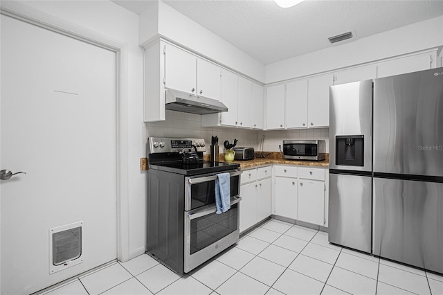 12178 Palmetto Way, Dunnellon, FL 34432 - kitchen featuring stainless steel appliances, under cabinet range hood, white cabinetry, light tile patterned floors, and backsplash