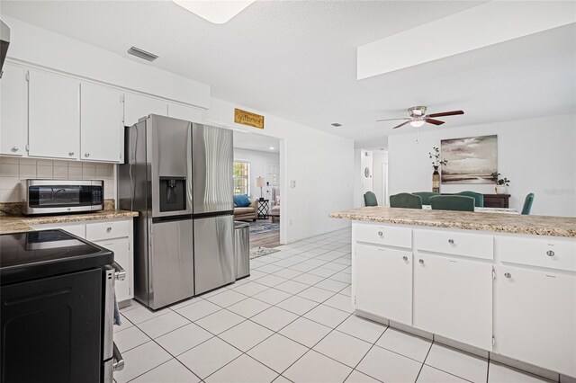12178 Palmetto Way, Dunnellon, FL 34432 - kitchen featuring stainless steel appliances, ceiling fan, light countertops, white cabinetry, and tasteful backsplash