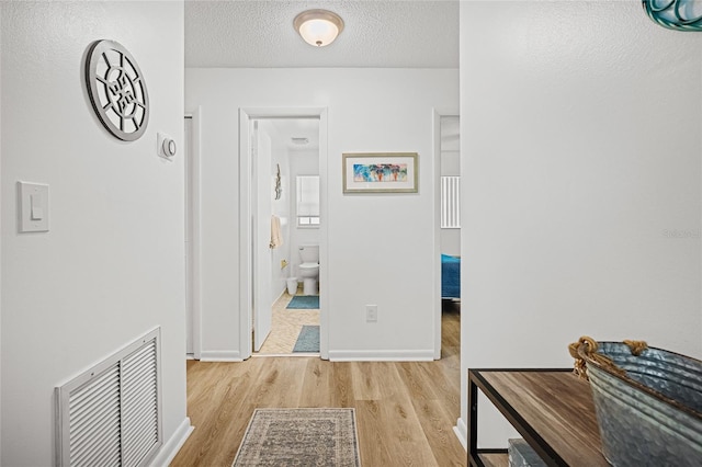 12178 Palmetto Way, Dunnellon, FL 34432 - corridor featuring light wood-style flooring and a textured ceiling