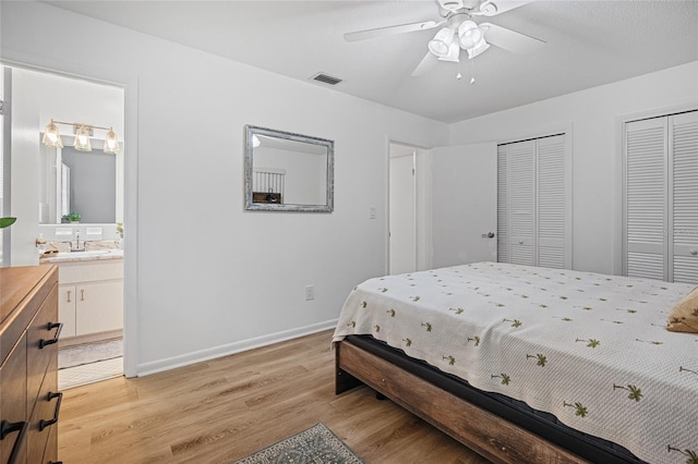 12178 Palmetto Way, Dunnellon, FL 34432 - bedroom featuring two closets, light wood-style flooring, connected bathroom, and ceiling fan