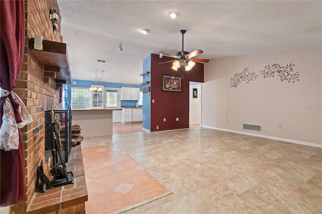 206 N Dundee Way, Inverness, FL 34450 - unfurnished living room featuring a textured ceiling, ceiling fan, a brick fireplace, and a chandelier