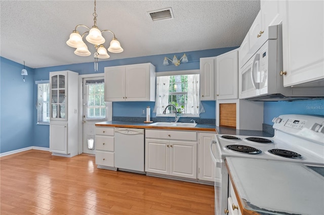 206 N Dundee Way, Inverness, FL 34450 - kitchen with white appliances, a chandelier, white cabinetry, a textured ceiling, and light wood-style flooring