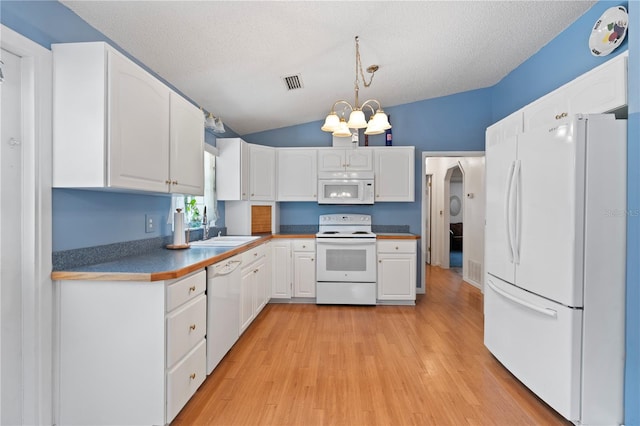 206 N Dundee Way, Inverness, FL 34450 - kitchen with white appliances, a chandelier, white cabinetry, light wood-style floors, and vaulted ceiling