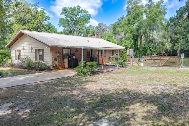 206 N Dundee Way, Inverness, FL 34450 - back of property with a gate, brick siding, and a metal roof