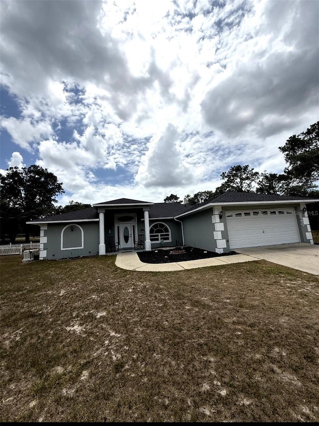 2550 SW Ivy Pl, Dunnellon, FL 34431 - view of front of property featuring driveway, an attached garage, a front yard, and stucco siding