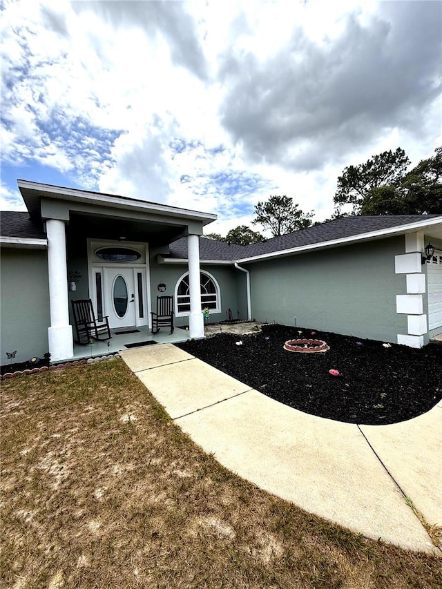 2550 SW Ivy Pl, Dunnellon, FL 34431 - doorway to property with stucco siding, an attached garage, and a yard