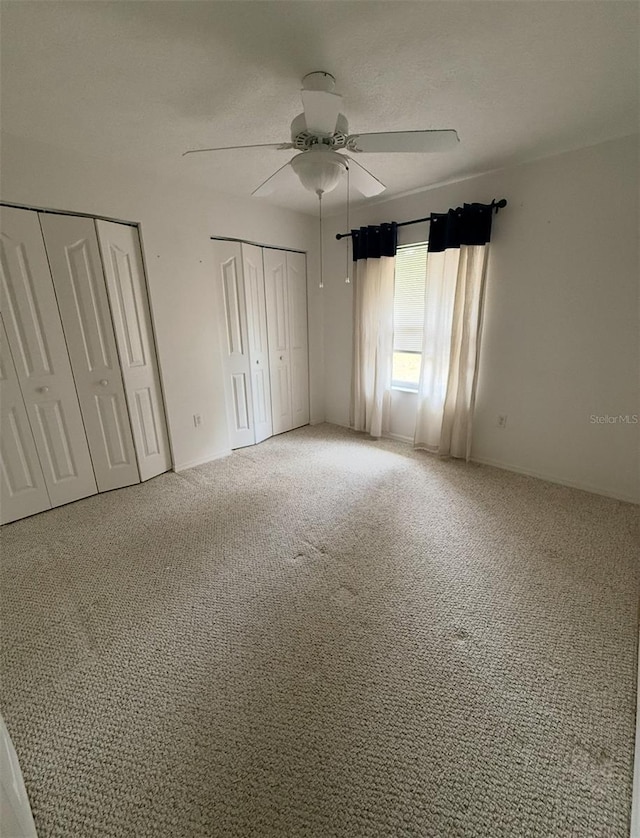 2550 SW Ivy Pl, Dunnellon, FL 34431 - unfurnished bedroom with two closets, carpet flooring, and ceiling fan