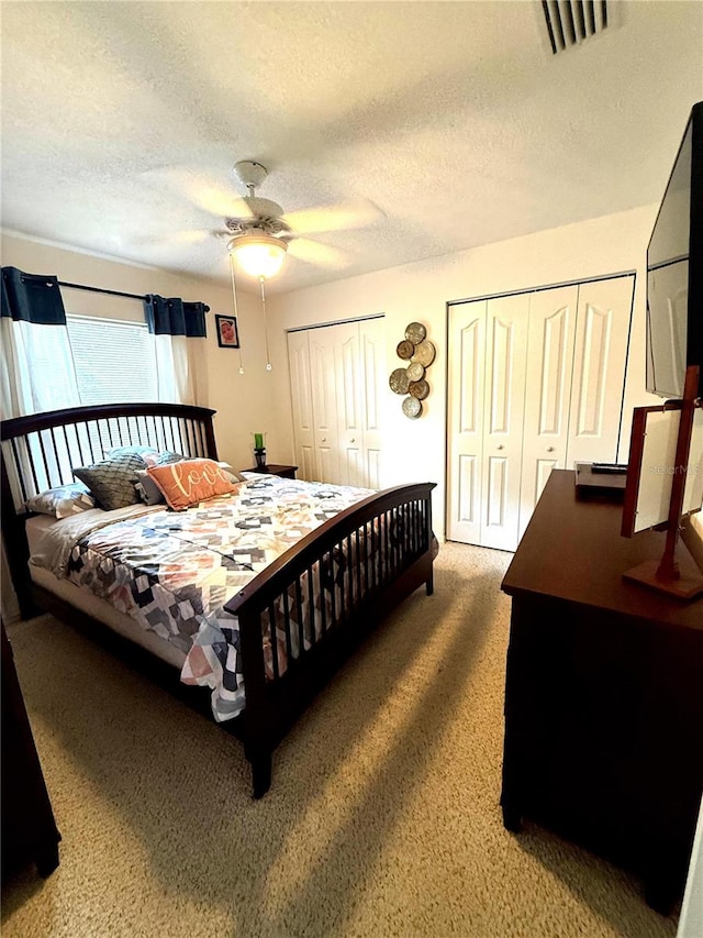 2550 SW Ivy Pl, Dunnellon, FL 34431 - bedroom featuring multiple closets, a textured ceiling, carpet flooring, and ceiling fan