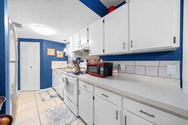 7961 Midway Drive Ter Unit J102, Ocala, FL 34472 - kitchen featuring white appliances, under cabinet range hood, backsplash, white cabinetry, and light countertops
