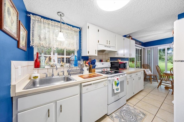 7961 Midway Drive Ter Unit J102, Ocala, FL 34472 - kitchen with white appliances, under cabinet range hood, tasteful backsplash, a textured ceiling, and white cabinets