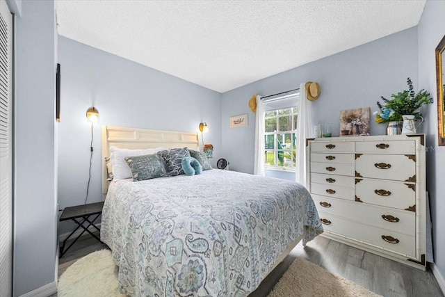 7961 Midway Drive Ter Unit J102, Ocala, FL 34472 - bedroom featuring wood finished floors and a textured ceiling