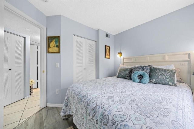 7961 Midway Drive Ter Unit J102, Ocala, FL 34472 - bedroom featuring wood finished floors, a textured ceiling, and multiple closets