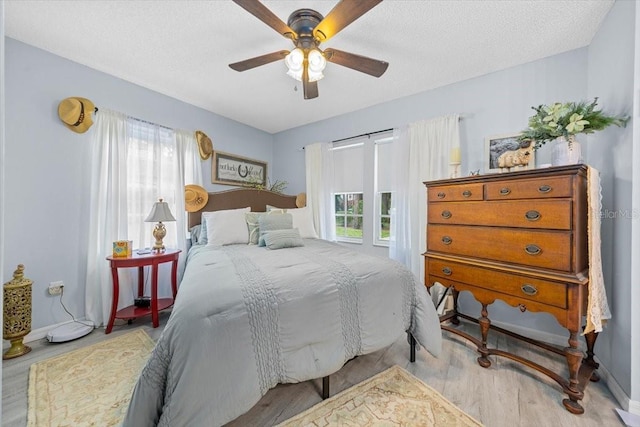 7961 Midway Drive Ter Unit J102, Ocala, FL 34472 - bedroom with multiple windows, ceiling fan, wood finished floors, and a textured ceiling