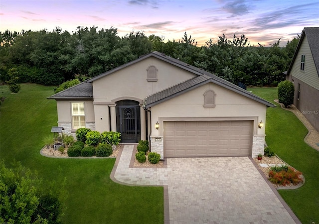 7839 SW 97th Cir, Ocala, FL 34481 - view of front facade with stucco siding, decorative driveway, an attached garage, a yard, and stone siding
