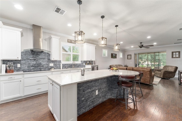 7839 SW 97th Cir, Ocala, FL 34481 - kitchen with wall chimney exhaust hood, open floor plan, a center island, plenty of natural light, and crown molding