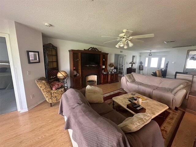 9730 SW 90th St, Ocala, FL 34481 - living area with a textured ceiling, ceiling fan, light wood-style flooring, and a fireplace