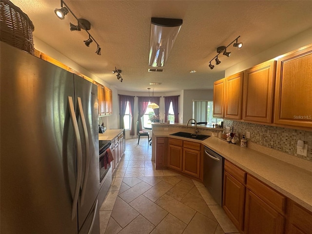9730 SW 90th St, Ocala, FL 34481 - kitchen with appliances with stainless steel finishes, rail lighting, a peninsula, light countertops, and a textured ceiling