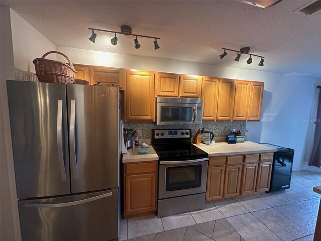 9730 SW 90th St, Ocala, FL 34481 - kitchen with stainless steel appliances, light countertops, tasteful backsplash, a textured ceiling, and light tile patterned floors