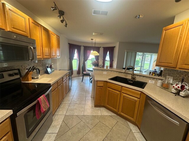 9730 SW 90th St, Ocala, FL 34481 - kitchen featuring stainless steel appliances, decorative backsplash, light countertops, and a peninsula