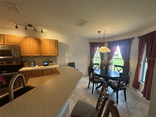 9730 SW 90th St, Ocala, FL 34481 - kitchen featuring appliances with stainless steel finishes, backsplash, pendant lighting, light tile patterned floors, and light countertops