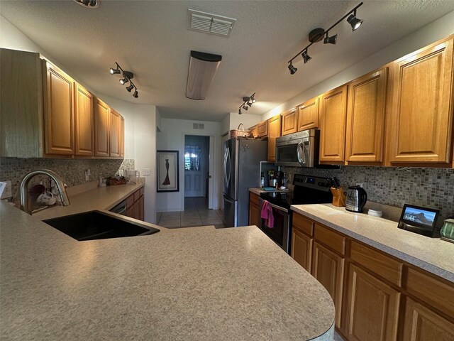 9730 SW 90th St, Ocala, FL 34481 - kitchen featuring appliances with stainless steel finishes, rail lighting, tasteful backsplash, a textured ceiling, and light countertops