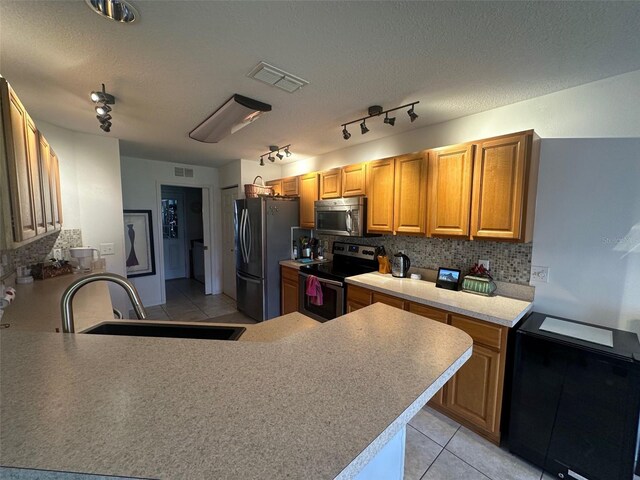 9730 SW 90th St, Ocala, FL 34481 - kitchen with stainless steel appliances, decorative backsplash, light tile patterned floors, light countertops, and a peninsula