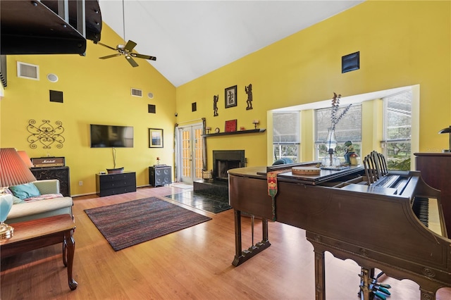 10230 289th St E, Myakka City, FL 34251 - living area featuring high vaulted ceiling, a ceiling fan, wood finished floors, and a fireplace with raised hearth