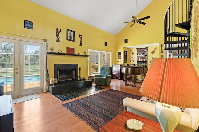 10230 289th St E, Myakka City, FL 34251 - living room with wood finished floors, a ceiling fan, high vaulted ceiling, a fireplace with raised hearth, and french doors