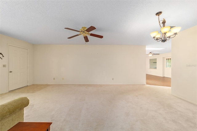 8704 SW 94th Ln Unit G, Ocala, FL 34481 - unfurnished living room with a ceiling fan, a chandelier, light colored carpet, and a textured ceiling