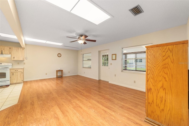 8704 SW 94th Ln Unit G, Ocala, FL 34481 - unfurnished living room featuring ceiling fan, light wood-style flooring, and a skylight